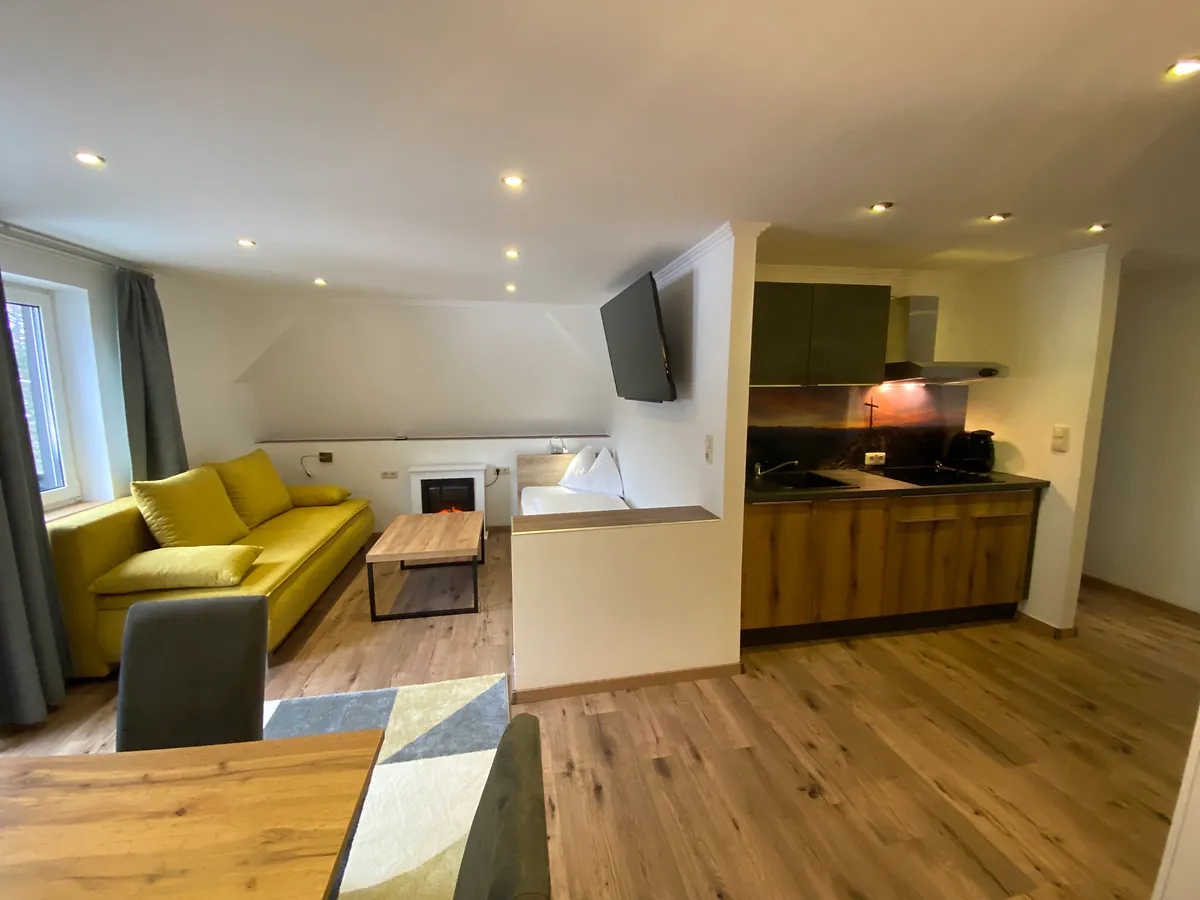 Wohnbereich im Apartment Ankogel mit Esstisch Küche Schlafsofa und Einzelbett bei GRUBERS Hotel Apartments Gastein