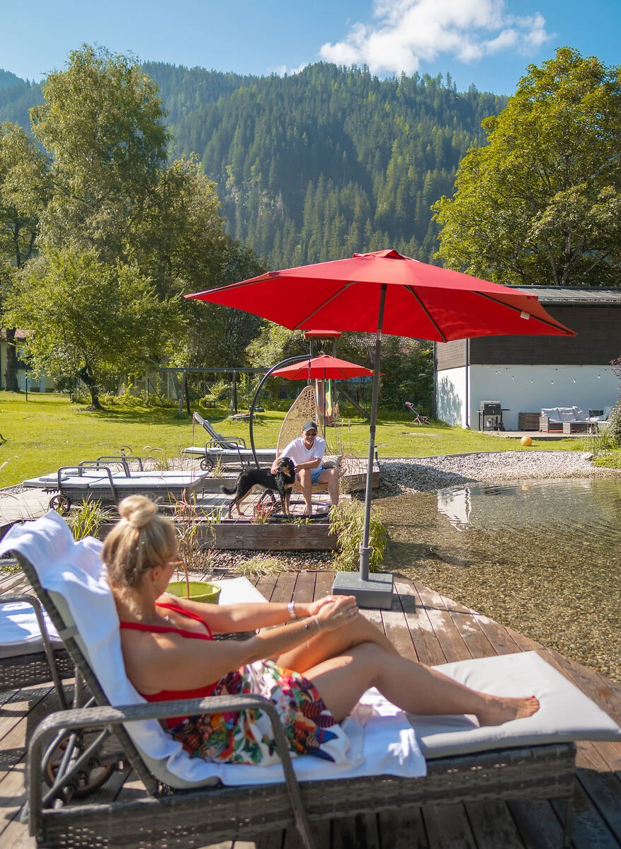 Gäste am Hundebadeteich im großen Garten bei GRUBERS Hotel Apartments Gastein Urlaub mit Hund