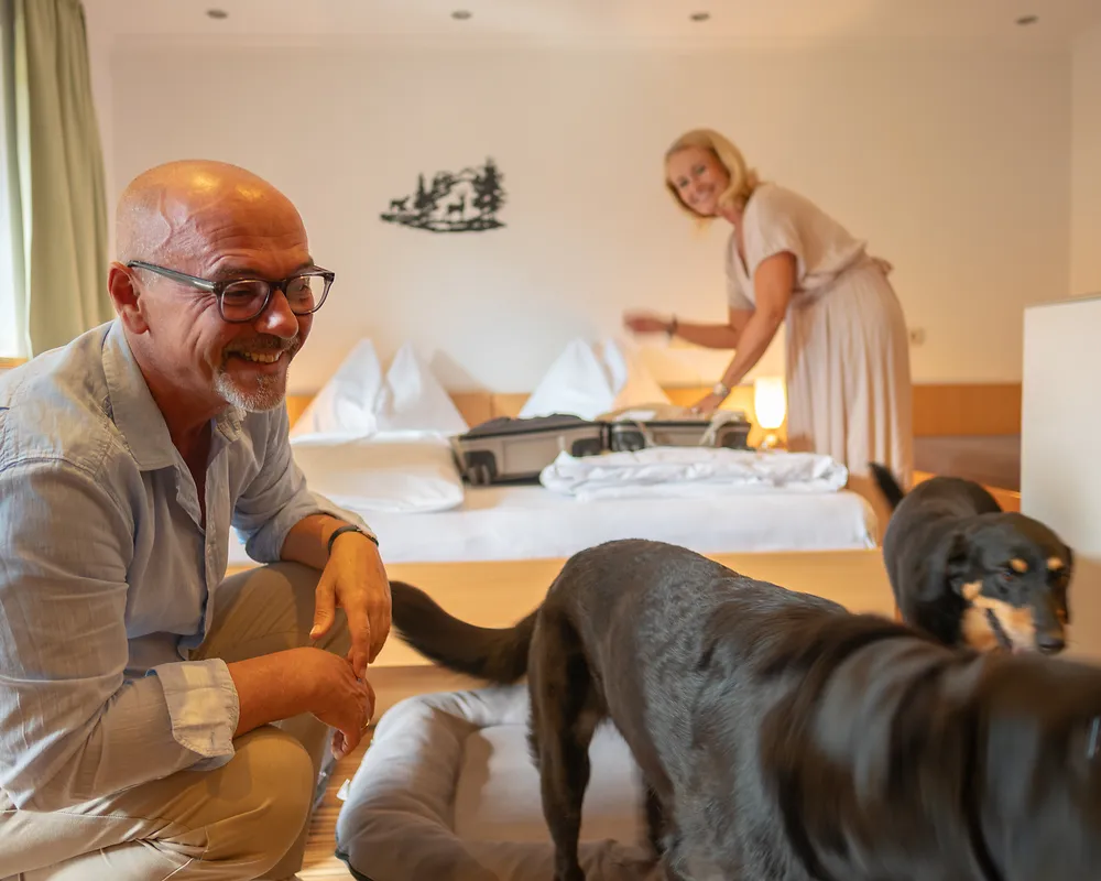 Gäste mit Hund im Zimmer der GRUBERS Hotel-Apartments in Bad Gastein