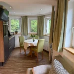 Apartment mit Hund Bad Gastein Wohnbereich mit Küche im Erker und gemütlicher Couch