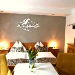 Doppelbett im Doppelzimmer Palfnersee mit kleinem Sitzbereich und Tisch