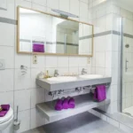 Badezimmer im Familienzimmer Bockhartsee mit Dusche und modernem Waschtisch in Bad Gastein