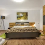 Schlafzimmer im Familienzimmer Bockhartsee für 5 Personen mit Doppelbett und zusätzlicher Schlafmöglichkeit in Bad Gastein